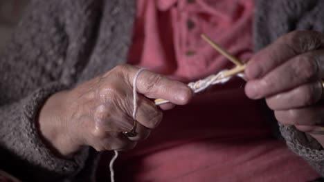 Elderly-lady's-hands-knitting-close-up-slow-panning-shot