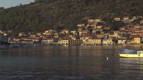 Schwenkansicht-Der-Boote,-Die-Entlang-Der-Küste-Von-Vela-Luka-In-Kroatien-Und-Seinen-Hügeln-Angedockt-Sind