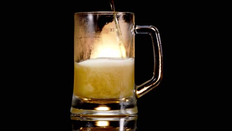Pouring-Lager-Beer-Into-A-Glass-Tankard-In-Black-Background-With-Light---studio-shot