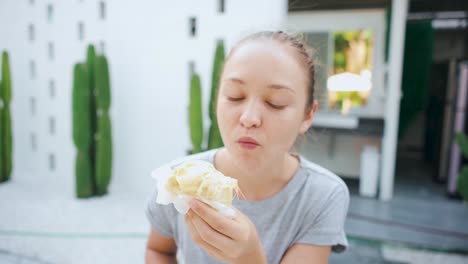 Blonde-Frau,-Die-Im-Freien-Leckeren-Durian-Isst