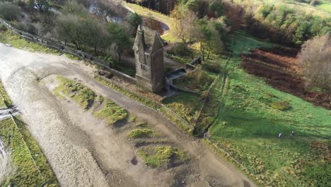 Historic-creepy-fairy-tale-Rivington-pigeon-tower-aerial-tilt-down-over-view-in-English-Winter-hill-farming-countryside