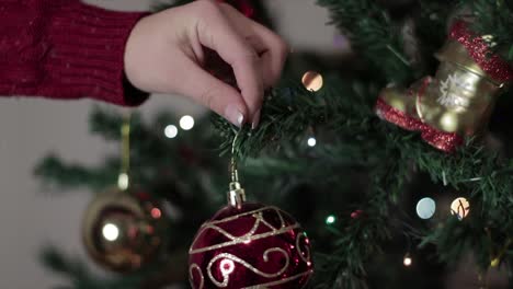 Person-hanging-up-Christmas-ornaments-and-decorations
