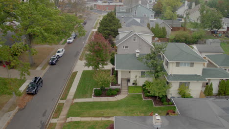 Aerial-view-of-suburban-street-in-Fall-with-a-pan-to-the-right-to-reveal-houses