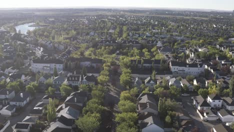 summer-sunrise-arial-rise-fly-over-Calgary-suburb-of-Inverness-town-of-McKenzie-Highands-residential-community-of-low-rise-town-homes-detauched-apartments-by-manmade-ponds-parks-promenade-way-AB-CAN