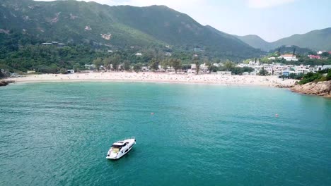 A-static-aerial-view-of-a-yacht-at-the-Shek-O-beach-in-Hong-Kong-as-public-beaches-reopening,-after-months-of-closure-amid-coronavirus-outbreak,-to-the-public