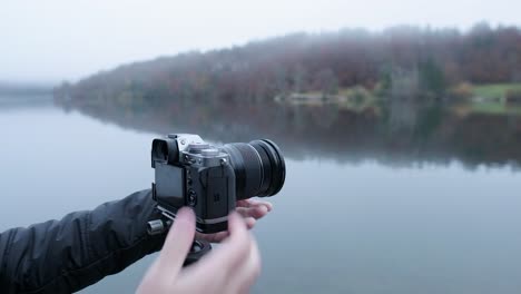 Photographer-changing-a-camera-on-a-tripod-from-landscape-orientation-to-vertical-orientation-in-gloomy-conditions