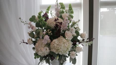 Wunderschöner-Blumenstrauß,-Umgeben-Von-Eleganten-Weißen-Vorhängen-Und-Atemberaubenden-Fenstern-Voller-Sonnenlicht