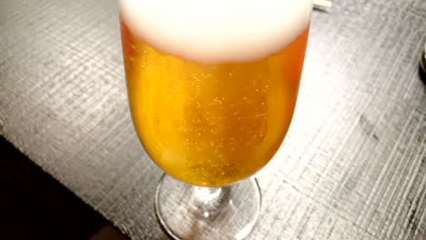 Nahaufnahme-Von-Goldenem-Bier,-Aufsteigenden-Blasen-Und-Weißem-Schaum