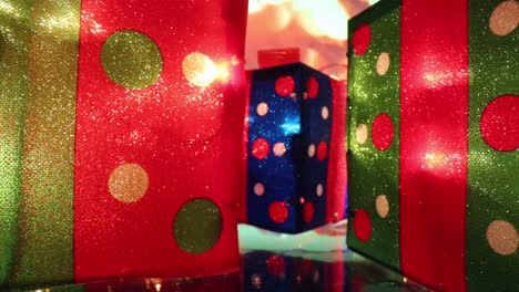 Moving-away-from-polka-dotted-red---blue-illuminated-Christmas-present-in-the-middle-as-the-background-changes-colors