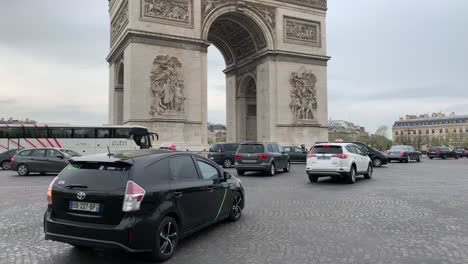 Cars-going-around-the-roundabout-of-the-Arc-de-Triomphe,-one-of-the-major-landmarks-of-Paris,-France