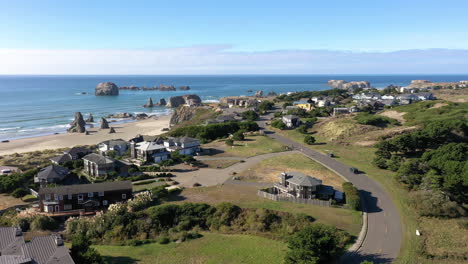 Aerial-View-Of-The-Modern-Houses-At-Bandon-City-in-Oregon-With-Turquoise-Water-and-Glorious-Trees-During-Sunny-Day---Aerial-Shot