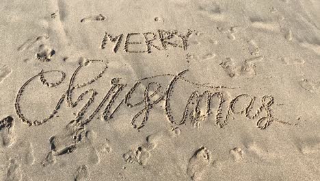 Merry-Christmas-written-in-sand-with-cursive-writing