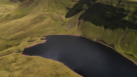 Llyn-y-fan-Fach-Brecon-beacons-rural-Wales-mountain-valley-countryside-lake-wilderness-Aerial-tilt-up-dolly-left
