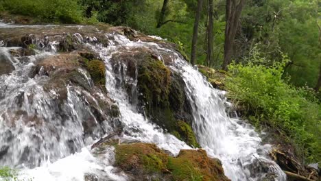 Water-flowing-over-a-rocky-formation-covered-in-moss-at-Krka-National-Park-in-Croatia-at-¼-speed