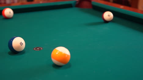 Person-Breaks-Pool-Balls-on-8-Ball-Triangle-Rack-and-makes-a-Ball-in-the-Corner-Pocket-Closeup-on-the-Spot-with-Solid-and-Stripped-Billiard-Balls-on-Table-with-Green-Felt-or-Cloth