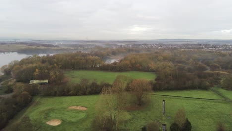 Foggy-dawn-misty-colourful-nature-reserve-autumn-woodland-landscape-aerial-pan-right