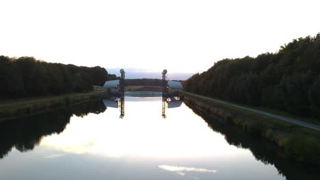 Small-river-dam-at-sunset-with-the-light-reflecting-over-the-calm-waters-of-its-channel