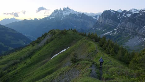 Mountain-biker-rides-down-a-scenic-ridge-at-dusk