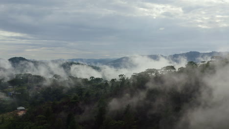 Wunderbarer-Drohnenblick-Auf-Bewölkte-Berge-Am-üppigen-Morgen-Grüner-Hügel,-Die-Von-Tropischen-Regenwolken-Bedeckt-Sind