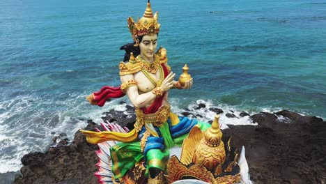 Statue-of-God-of-Baruna-riding-mina-elephant-at-Pererenan-beach,-Aerial-Orbit-shot