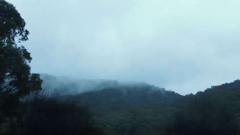 Rolling-Clouds-Over-Forested-Mountains-During-Foggy-Morning