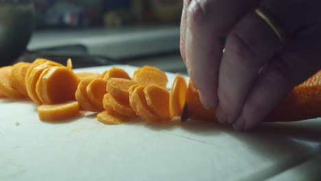 Chopping-carrot-into-thin-slices-by-hand-with-knife,-close-up