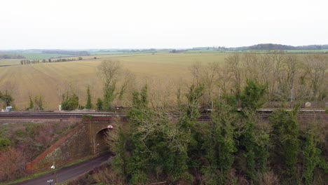 Drone-footage-of-a-fly-pass-of-a-train-track-in-Kent-countryside-with-railway-track-bridge