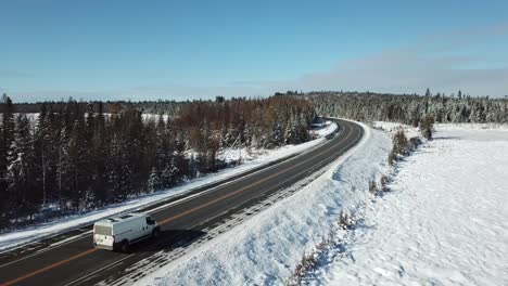 Van-Fährt-Durch-Kalten,-Sonnigen,-Blauen-Himmel-Wintertag-In-Der-Nördlichen-Landschaft-Kanadas---Drohne-4k-Antenne