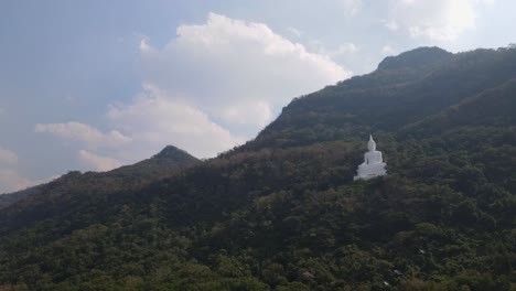 Luang-Por-Khao,-Wat-Theppitak-Punnaram,-descending-aerial-4K-footage-of-the-famous-Giant-White-Buddha-on-a-mountain-side-in-Pak-Chong,-Nakhon-Ratchasima-in-Thailand