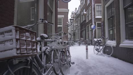 Bicycles-covered-in-heavy-winter-snow,-Leiden-city-streets-in-Netherlands