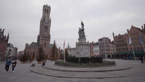 Belfry-on-the-market-square-with-statue-of-Jan-Breydel-and-Pieter-de-Coninck-during-Christmas-in-Bruges,-Belgium,-static-wide-angle
