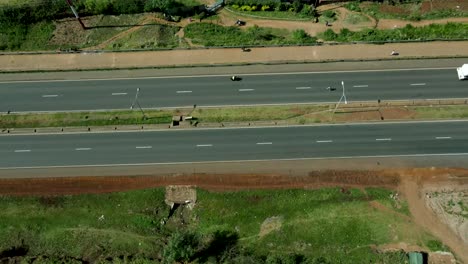 Aerial-flyover-african-highway-and-driving-vehicles-during-sunny-day