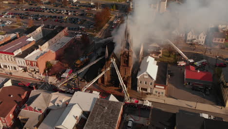Multiple-fire-departments-arriving-to-scene-of-burning-church,-Aerial,-Slow-Motion