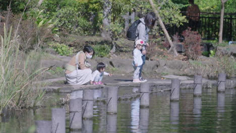 Mothers-With-Their-Daughters-Sightseeing-On-A-Sunny-Park-With-Serene-Lake-In-Tokyo,-Japan
