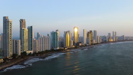 Aerial-Establishing-Shot-of-Beaches-and-Modern-Skyscrapers-at-Sunset-in-Cartagena,-Bolivar,-Colombia