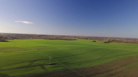 Drone-shot-of-rolling-green-fields-and-blue-skies