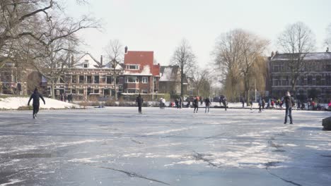 Niederländische-Einheimische-Eislaufen-Auf-Dem-Zugefrorenen-Fluss-In-Der-Stadt-Leiden