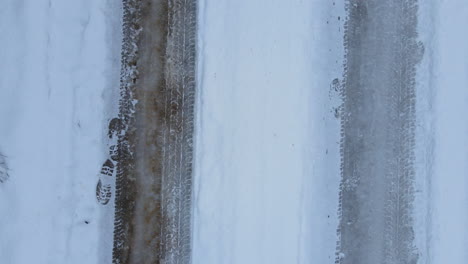 Top-Down-Reifenspuren-Auf-Schnee-Auf-Einer-Schneebedeckten-Straße,-Regelmäßige-Rückspur-In-Zeitlupe