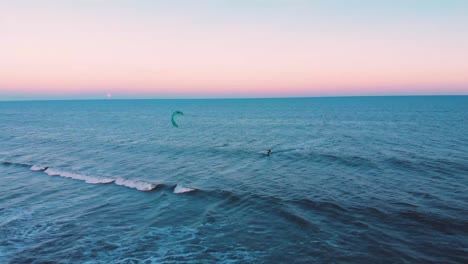 Kitesurfen-Allein-Im-Blauen,-Weiten-Ozean-Während-Des-Farbenfrohen,-Friedlichen-Sonnenuntergangs