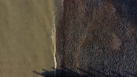 Sandy-sea-water-waves-hitting-the-pebble-beach-on-the-Kent-coast-of-Herne-Bay-in-UK