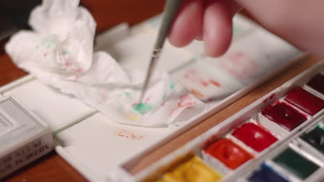 Hand-Wiping-The-Paint-Brush-Into-White-Tissue