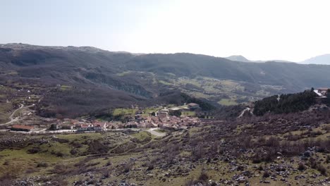 Aerial-panoramic-landscape-view-of-Pietraroja,-an-italian-village-on-top-of-a-hill,-on-a-sunny-day