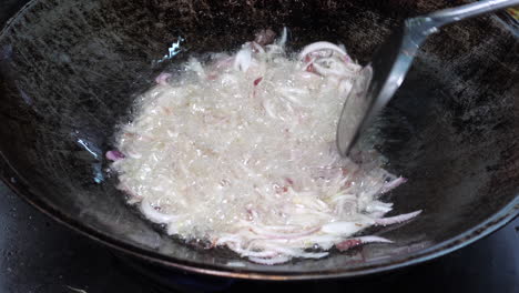 Close-up-shot-Spatula-stir-Frying-chopped-red-onion-in-pan---Food-preparation