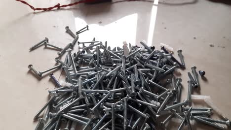 small-nails,-nuts,-and-bolts-scattered-on-top-of-the-Whiteboard