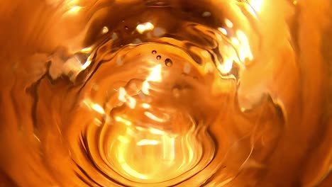 Goldener-Effekt-Von-Wassertropfen,-Die-In-Volles-Glas-Fallen