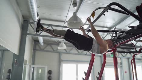 Strong-disabled-athlete-with-prosthetic-leg-do-hanging-leg-excercise-at-the-gym