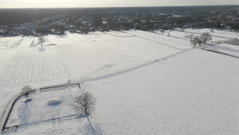 Aerial-of-snow-covered-fields-at-the-edge-of-rural-town