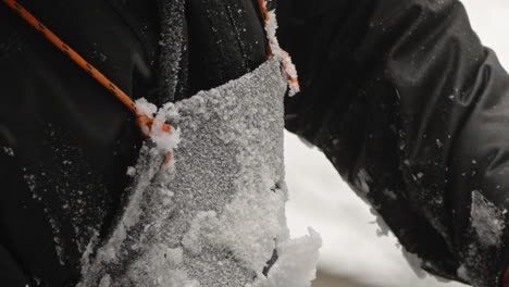 Snow-and-ice-shavings-frozen-to-sculptor's-apron,-Slow-Motion