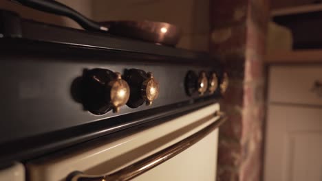 close-up-view-of-old-kitchen-fire-knobs-oven-with-metal-pan-on-top