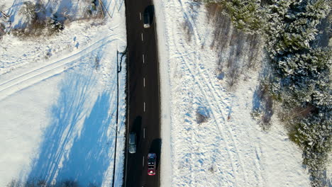 Mutlple-cars-driving-in-opposite-directions-over-a-two-lanes-road-cleared-from-snow-in-a-winter-wonderland-near-Gdansk-Poland-on-a-sunny-day